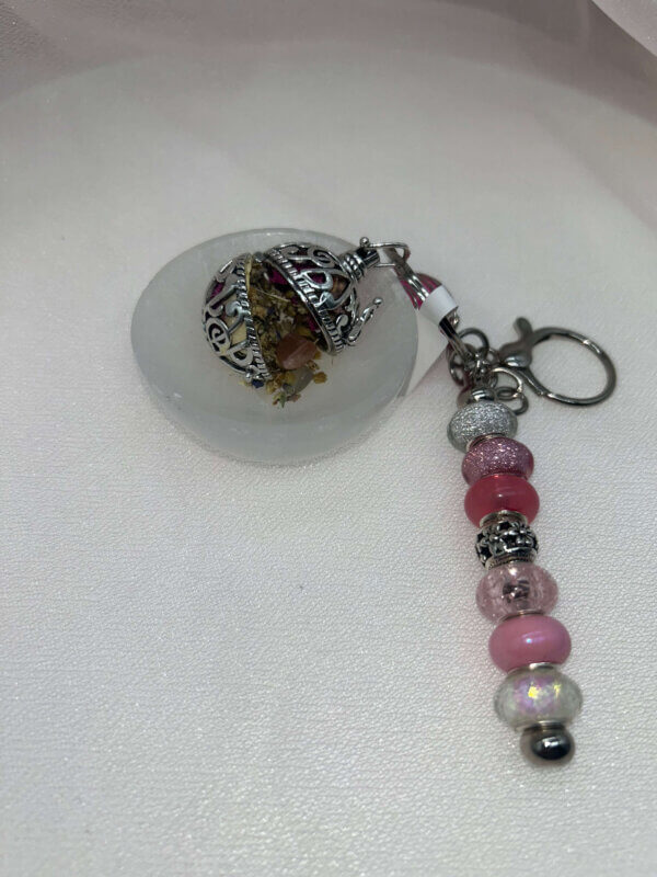 Keychain with Open Orb with Crystals, Herbs, and Flowers Inside. Keychain with Open Orb with Crystals, Herbs, and Flowers Inside.